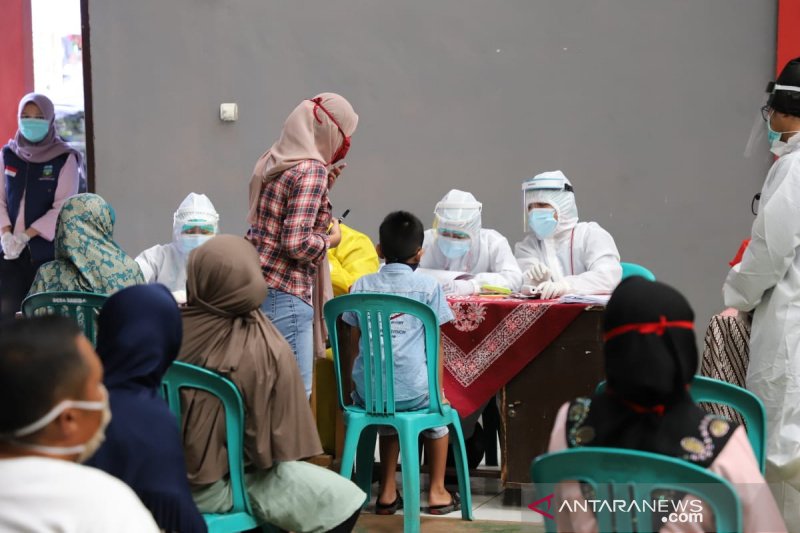 Petugas laksanakan tes usap pedagang dan pengunjung pasar tradisional di Garut