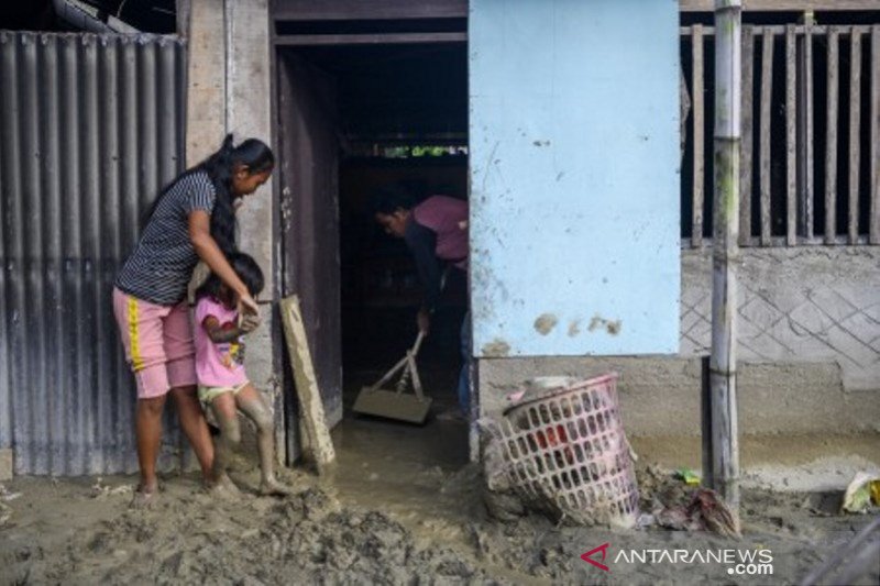 Warga bersihkan rumahnya dari lumpur akibat banjir