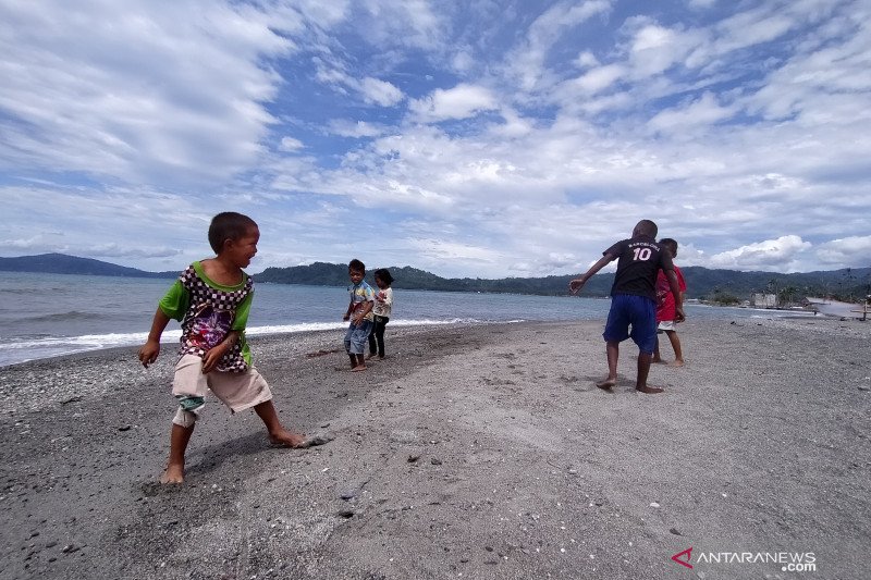 Anak-anak korban tsunami bermain di pantai