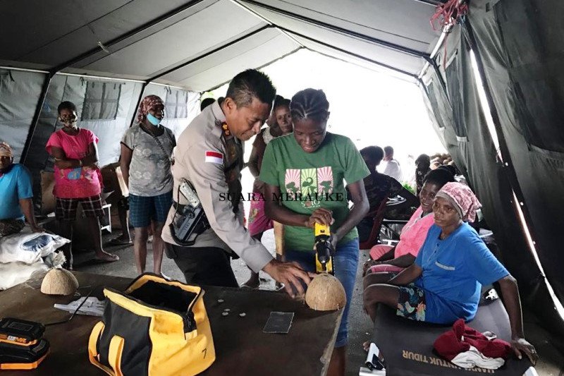 Remaja putri Asmat mahir membuat kancing  baju dari batok  