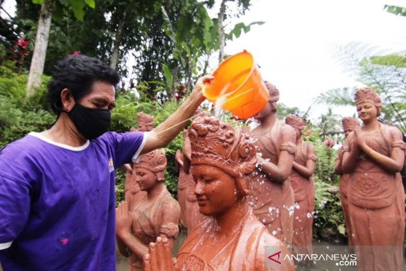 Bersihkan Patung Gandrung Dari Abu Vulkanik