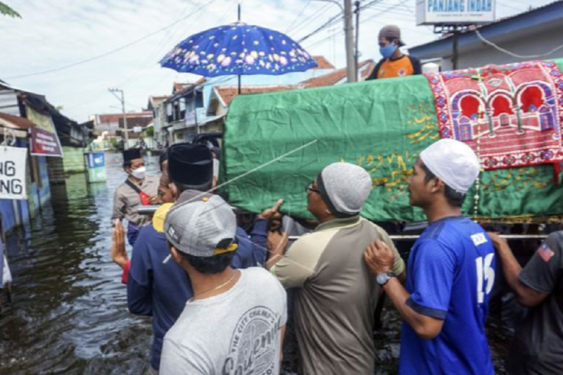 Membawa jenazah melewati banjir