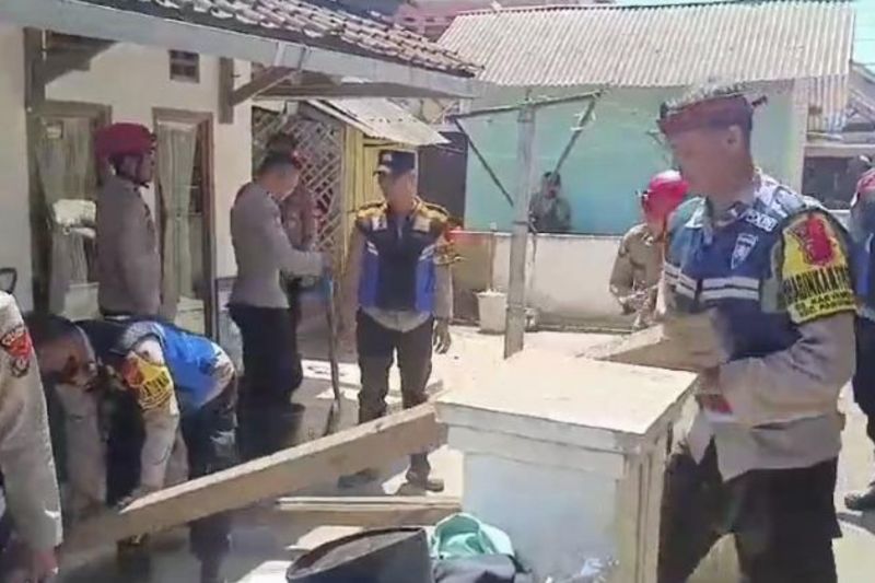 Personel Polres Garut membersihkan material rumah rusak akibat gempa