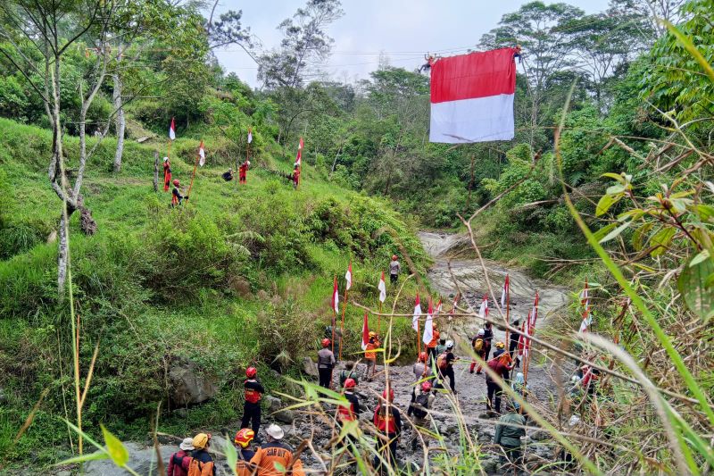 Pengibaran bendera merah putih di atas sungai kaki Gunung Merapi