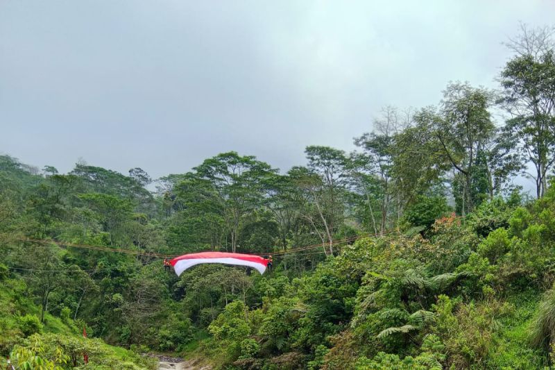 Pengibaran bendera merah putih di atas sungai kaki Gunung Merapi