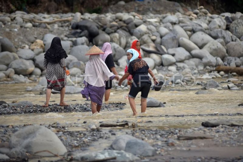 Warga menyeberangi sungai Batang Kuranji Padang